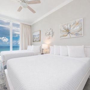 Wake to a breathtaking sunrise in this queen guest suite with two cozy beds and expansive views from the windows