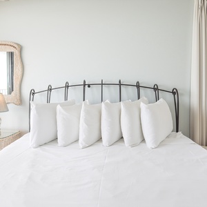 This inviting bedroom features a plush bed with decorative pillows and a lovely view through the large window