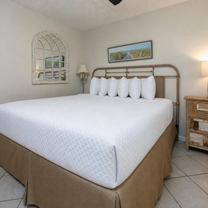 Cozy bedroom featuring a plush king bed, decorative pillows, and stylish wooden furniture for a relaxing retreat