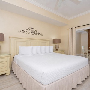 Bright and inviting master bedroom featuring a king bed, stylish decor, and a lovely view of the dining area and balcony