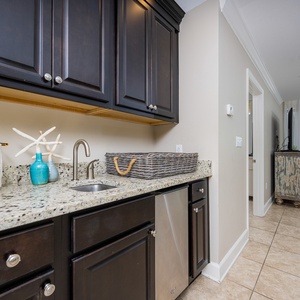 Enjoy preparing snacks at the stylish wet bar with charming coastal decor and an ice maker