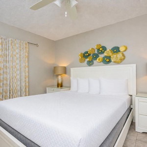 Queen bed in the guest suite invites restful nights beneath the gentle hum of the ceiling fan