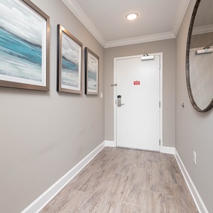 Step into a welcoming hallway adorned with calming art, setting the tone for your coastal getaway experience