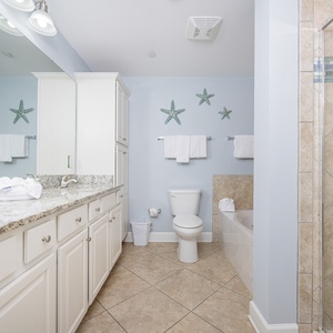 Refresh in the master bath after a day at the beach with a soothing tub and relaxing walk-in shower
