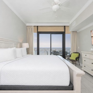 Relax in the master bedroom featuring a king bed, large TV, and beachfront balcony access