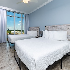 Enjoy an evening sunset in this queen suite with floor-to-ceiling windows showcasing coastal views