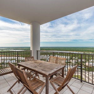 This balcony offers a stunning area view with a wooden dining set, perfect for enjoying outdoor meals