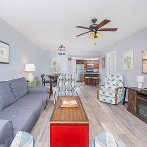 Spacious living area with comfortable seating, a rustic coffee table, and a view into the kitchen