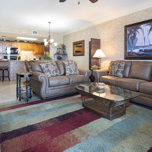 Unwind in the comfortable living area featuring leather sofas, a glass coffee table, and vibrant area rugs