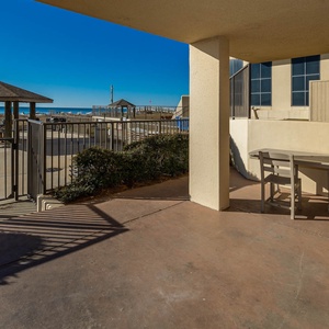 A private patio features outdoor seating and a view of the beach front, inviting guests to relax in the coastal breeze