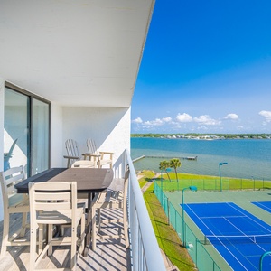 Enjoy the coastal vibe as you relax at your dining table, taking in views of the lagoon and courts below