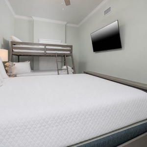 Unwind with a movie in this cozy bunk room with fun decor, a queen bed, and twin over double bunk