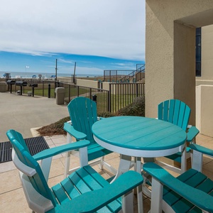 Outdoor ground floor patio with vibrant furniture and direct access to the beach and pool area