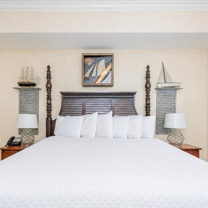 Cozy master bedroom featuring a plush king bed, nautical decor, and soft lighting for a relaxing retreat