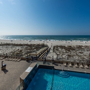Enjoy the inviting pool area with lounge chairs, perfect for relaxing while taking in the beach views