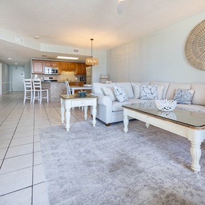 Spacious living area with a sofa with queen sleeper, beach balcony access, and a view of the dining space and kitchen