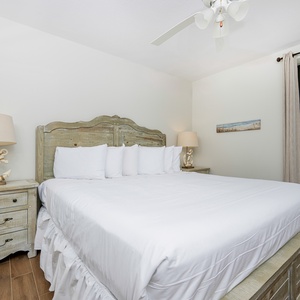 This guest bedroom features a large, inviting bed with white linens, complemented by rustic decor and a serene view