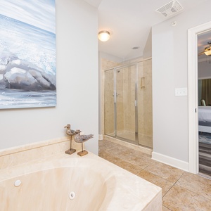 The master bath features a luxurious tub, a glass walk-in shower, and a serene view leading to the inviting bedroom area