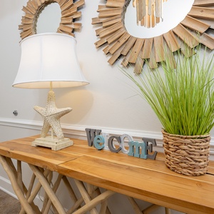 A welcoming entryway features a starfish lamp, greenery, and a charming 