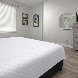 Cozy bedroom featuring a comfortable king bed, a TV, and charming decor with framed artwork, creating a welcoming atmosphere