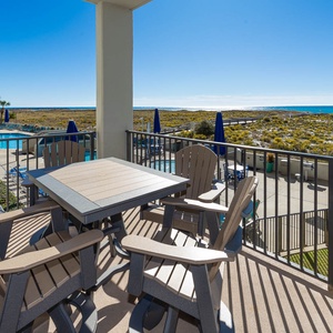 Balcony seating overlooks the pool area and the beach, offering a serene spot to enjoy the gulf view and coastal breeze