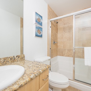 Guest bathroom featuring a granite countertop, modern fixtures, and a walk-in shower for a refreshing experience