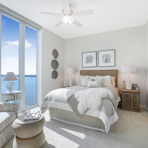 The guest bedroom features a cozy bed, stylish decor, and stunning views through large windows, perfect for relaxation