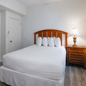 Cozy guest bedroom featuring a comfortable queen bed with plush pillows and warm accents, perfect for a restful getaway