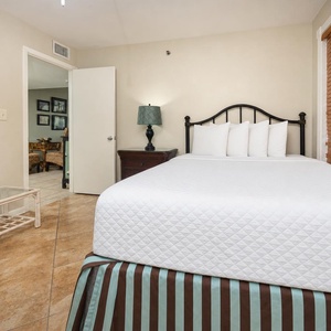 This guest bedroom features a comfortable queen bed, a stylish lamp, and a welcoming ambiance, perfect for relaxation