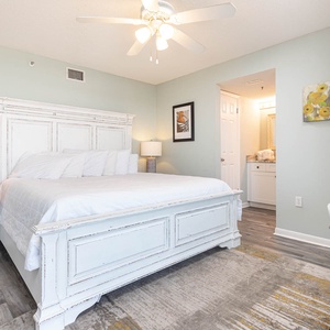 Brightly decorated master bedroom featuring a king bed, stylish nightstand, and a cozy workspace with complementary WiFi