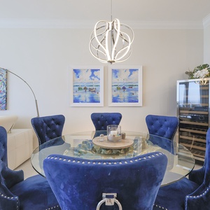 Admire sailboat art and the modern pendant lighting while settling into tufted dining seats