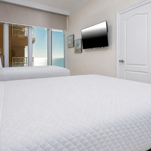 Experience a beach sunrise in this queen guest suite with two cozy beds and stunning views