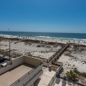 This stunning view showcases a beachfront scene with soft sand, inviting beach chairs, and a glimpse of the sparkling water