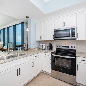 Prepare meals in the stylish kitchen with granite countertops, stainless appliances, and stunning beach view