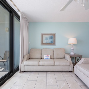 Light fills the living room from the balcony as you relax on the sofa with a queen sleeper