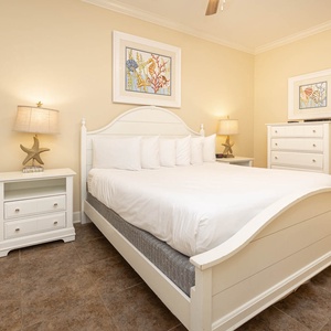 This bright bedroom features a comfortable king bed, charming coastal decor, and a TV for relaxing evenings
