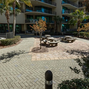 Stroll through the lush courtyard, where stone tables invite friendly gatherings amidst swaying palms