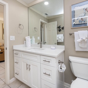Sleek bathroom featuring a vanity with a spacious countertop, tub/shower combo, fresh towels, and decorative art
