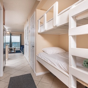 This cozy alcove features a built-in bunk bed, perfect for kids, with a view of the inviting living area and beach front