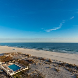 Experience stunning beachfront views with a serene atmosphere and a glimpse of the inviting pool below