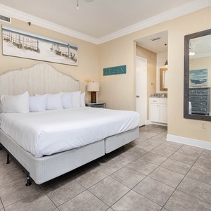 Master bedroom featuring a king bed, coastal decor, and a convenient en-suite bathroom with a stylish mirror