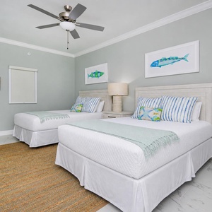 Sleep comfortably in this charming guest bedroom featuring two queen beds, coastal decor, and soothing colors