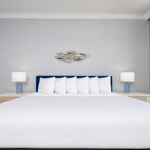 Experience restful nights in the master with a king bed, complemented by stylish lamps and coastal decor