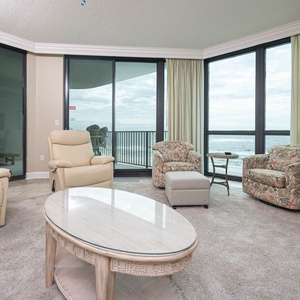 Unwind in this spacious living area with plush seating, large windows, and easy access to the balcony for fresh air