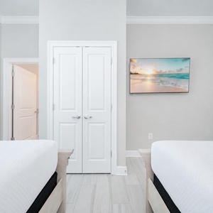 Relax in this guest bedroom featuring two comfortable queen beds, a TV, and soft decor that invites restful nights