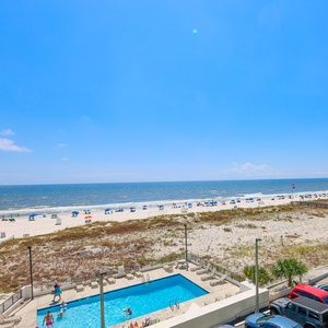 Enjoy relaxing beachfront views from this inviting space, featuring a sparkling pool and vibrant beach umbrellas