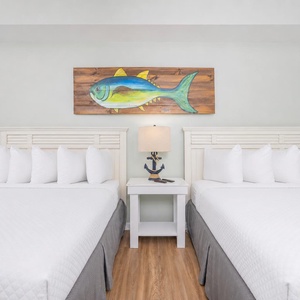 Two queen beds in the guest suite invite you to relax after a day filled with coastal adventures and fun