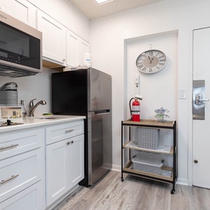 The kitchen features white cabinets, stainless appliances, and a convenient wet bar area for a delightful cooking experience