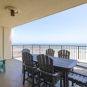 Enjoy breathtaking views from the spacious balcony, featuring a dining table and vibrant turquoise seating