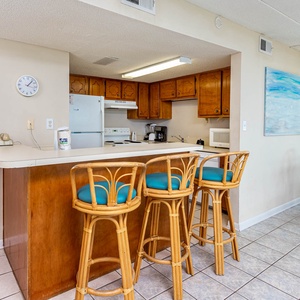 This inviting kitchen features wooden cabinetry, a breakfast bar with stylish seating, and a cozy dining area